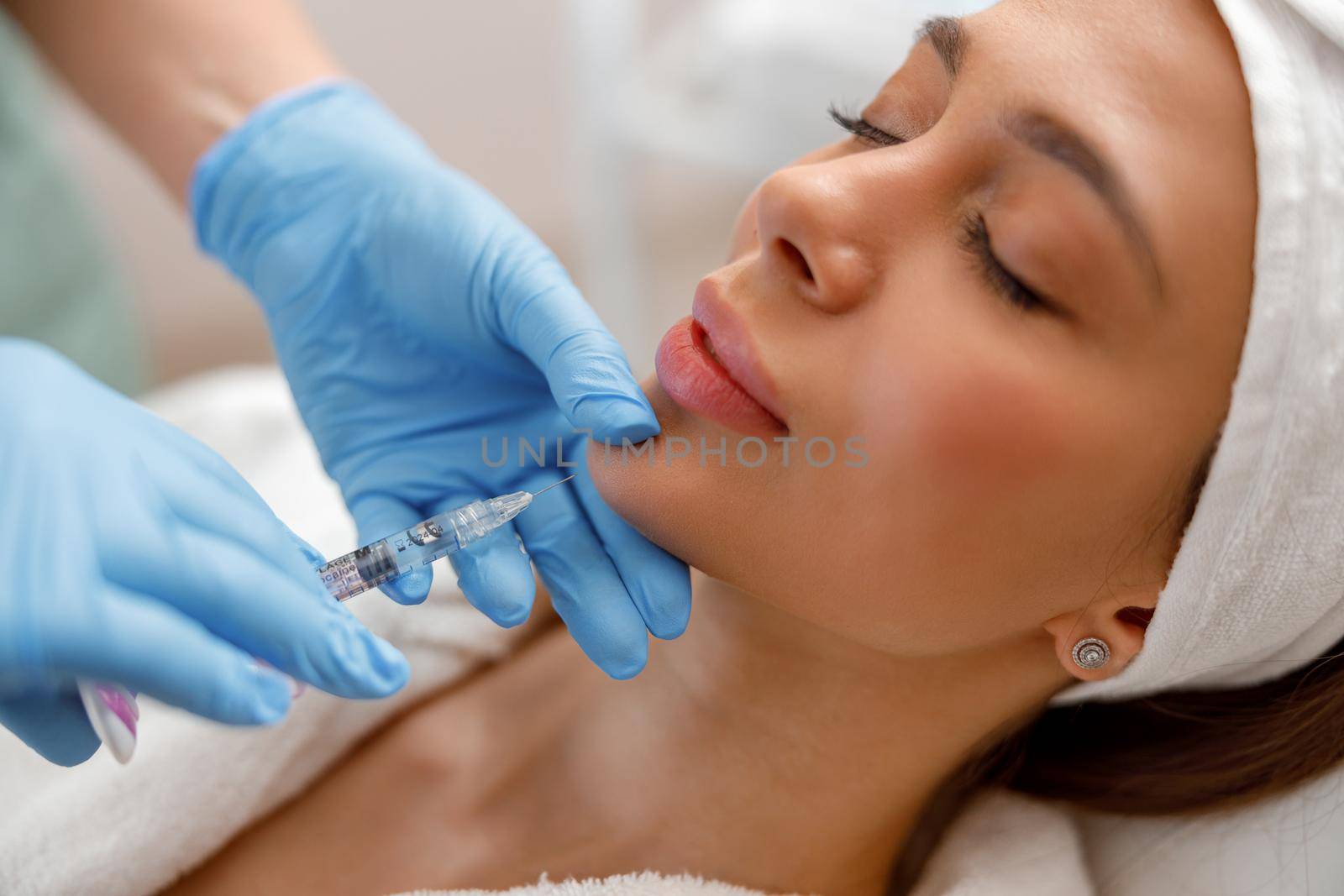 Closeup of young woman receiving hyaluronic acid injection in beauty salon. Cosmetology