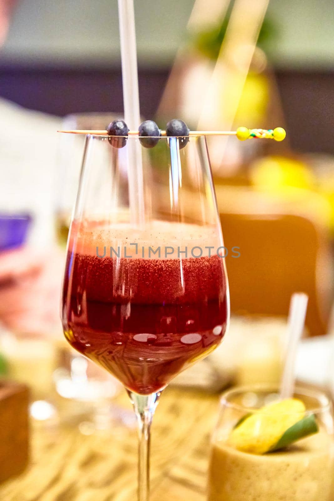 Cocktail or smoothie in a wine glass is on the table