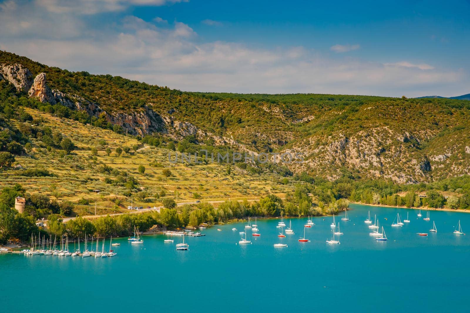 The city on the bank of the artificial lake in France, Provence, lake Saint Cross, gorge Verdone, azure water of the lake and slopes of mountains on a background, small boats, vacations place. High quality photo