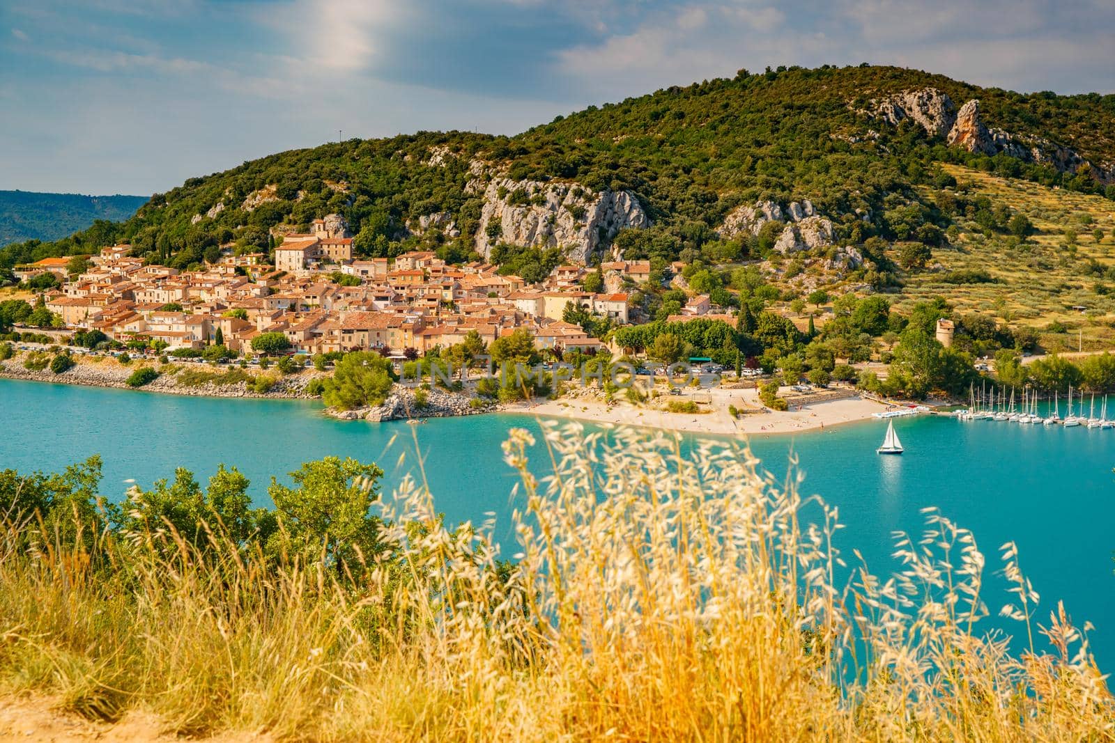 The city on the bank of the artificial lake in France, Provence, lake Saint Cross, gorge Verdone, azure water of the lake and slopes of mountains on a background, small boats, vacations place. High quality photo