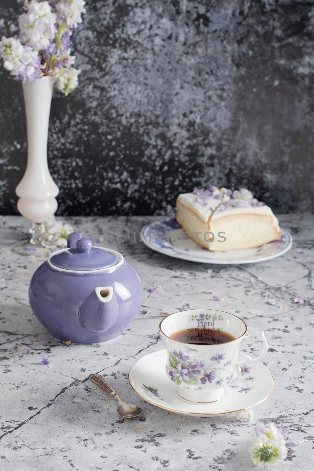 still life with black tea and cheese cake, spring bouquet of delicate lilac flowers. High quality photo