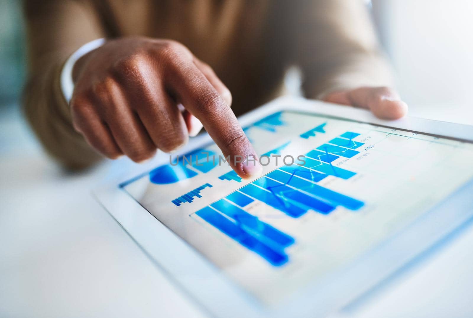 Reviewing the quantitative business data. Closeup shot of an unidentifiable businessman using a digital tablet in an office. by YuriArcurs