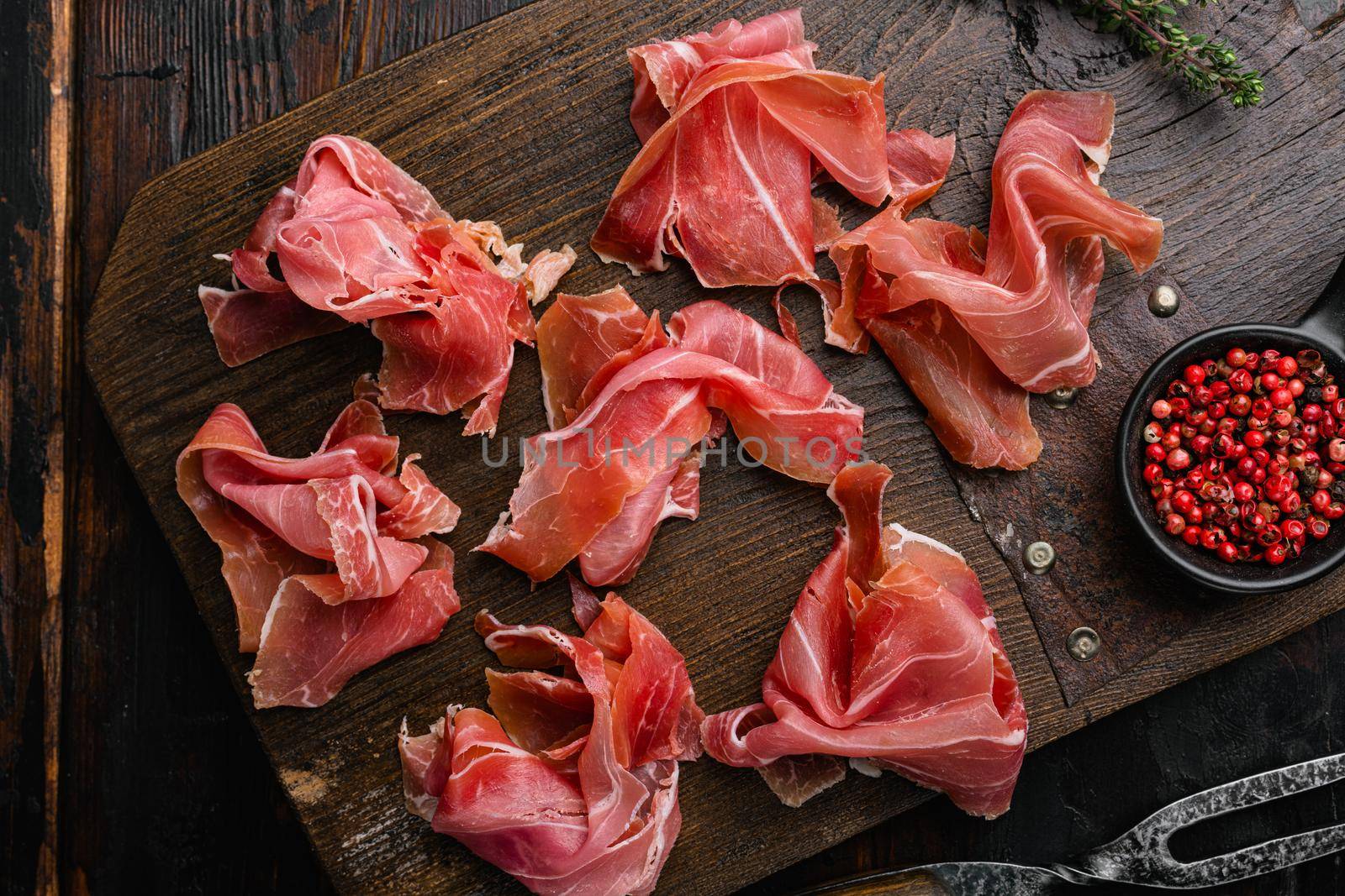 Italian prosciutto crudo or spanish jamon set, on old dark wooden table background, top view flat lay by Ilianesolenyi