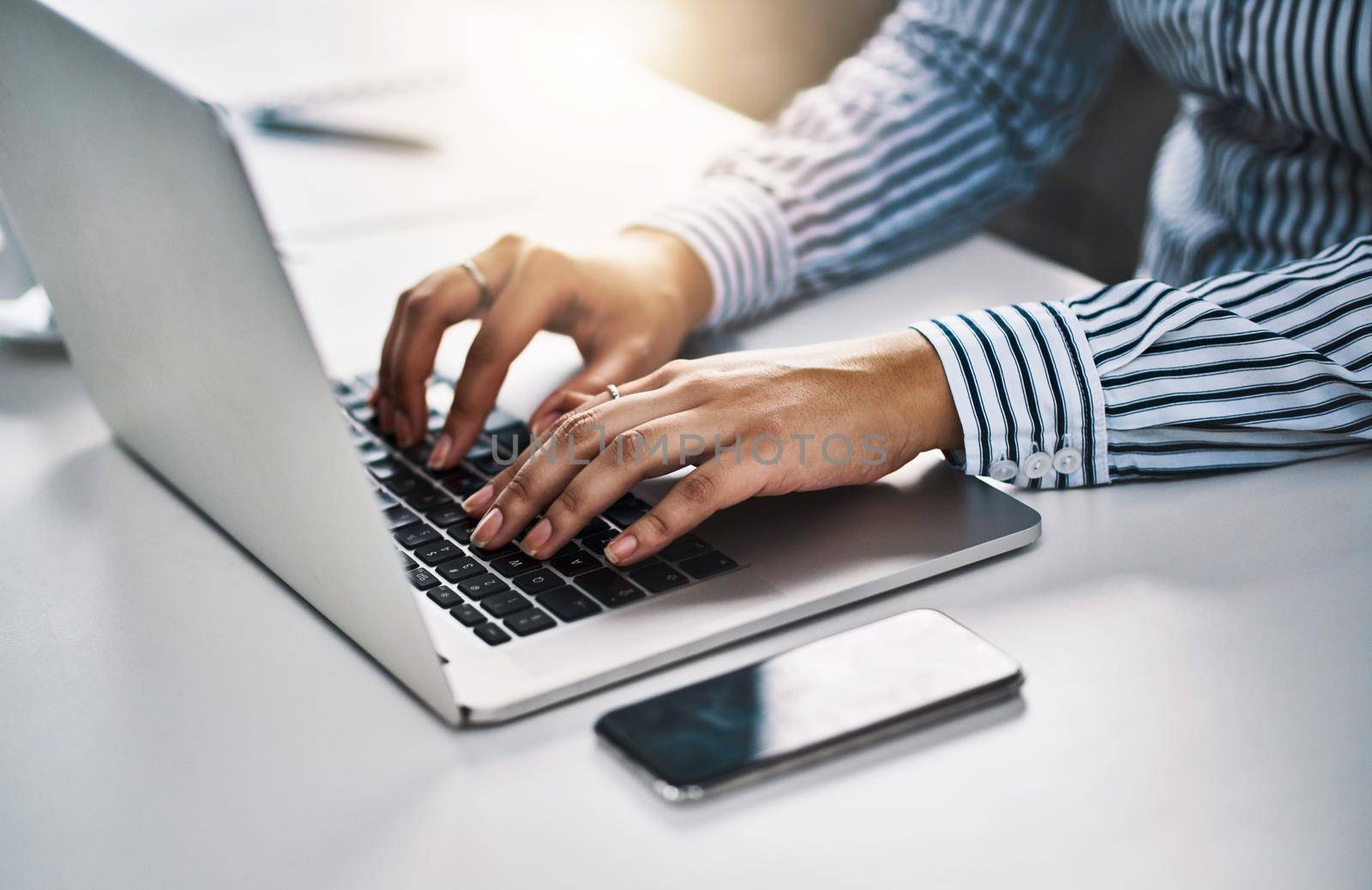 Closeup shot of an unrecognizable businesswoman working on a laptop in an office.