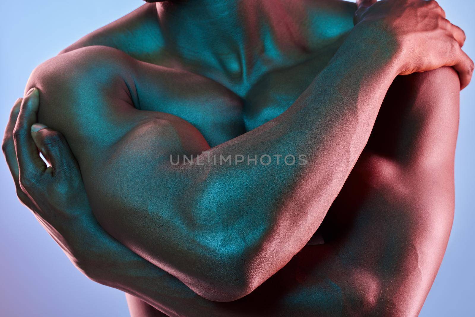 A bodybuilder is a sculptor who carries with him his own material. Shot of a muscular man posing against a studio background. by YuriArcurs