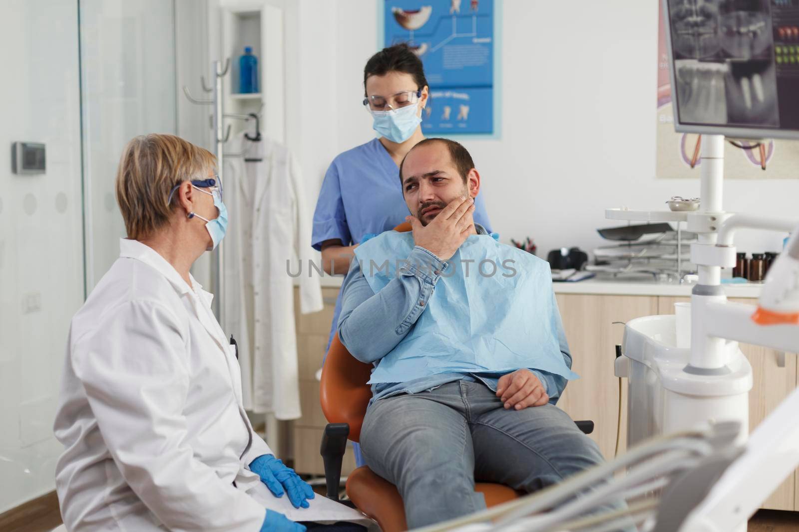 Orthodontist senior woman doctor explaining oral hygiene to patient with toothache discussing healthcare treatment during stomatological consultation in dental office room. Concept of medicine service