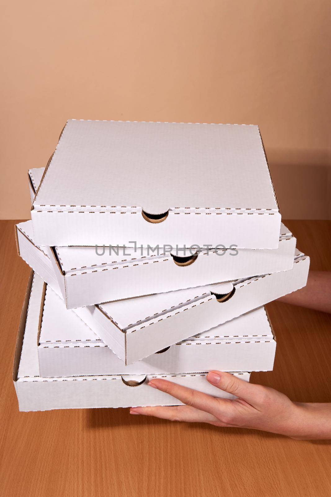 Delivery hands hold cardboard boxes, natural white color, eco-friendly and biodegradable products, boxes for the delivery of food and gifts, confectionery and food