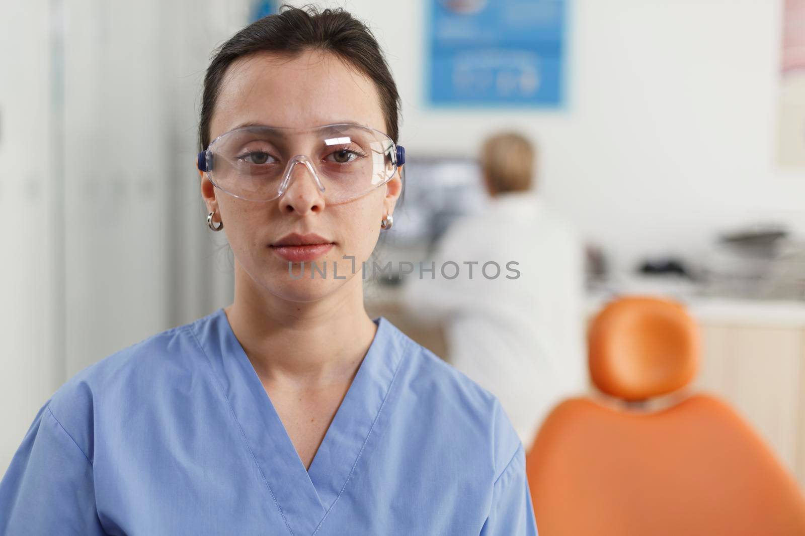 Closeup of stomatologist nurse working at stomatological treatment in dentistry medical office during dentistry examination. Medical team analyzing teeth radiography. Medicine services