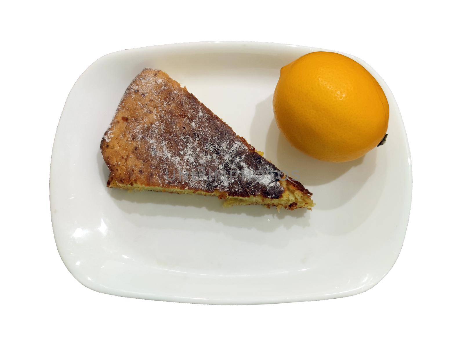 a piece of lemon biscuit and a fresh lemon on a plate, isolated.