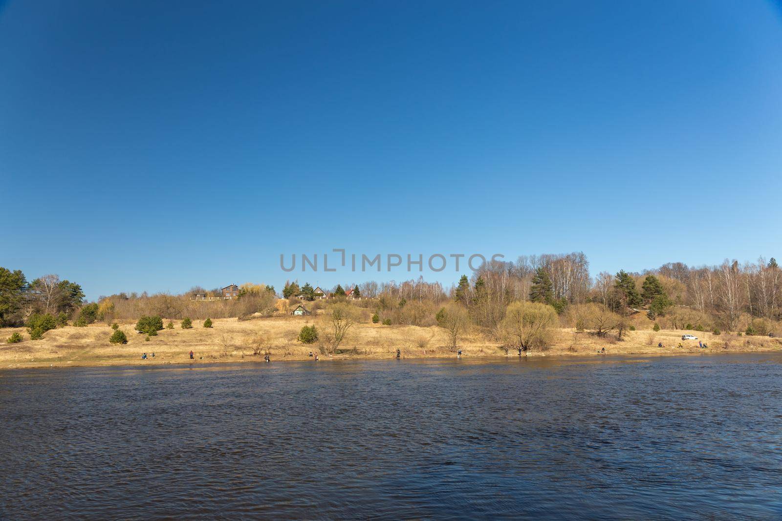 A lot of fishermans fishing with a rod on the shore of river Neman. Grodno, Belarus