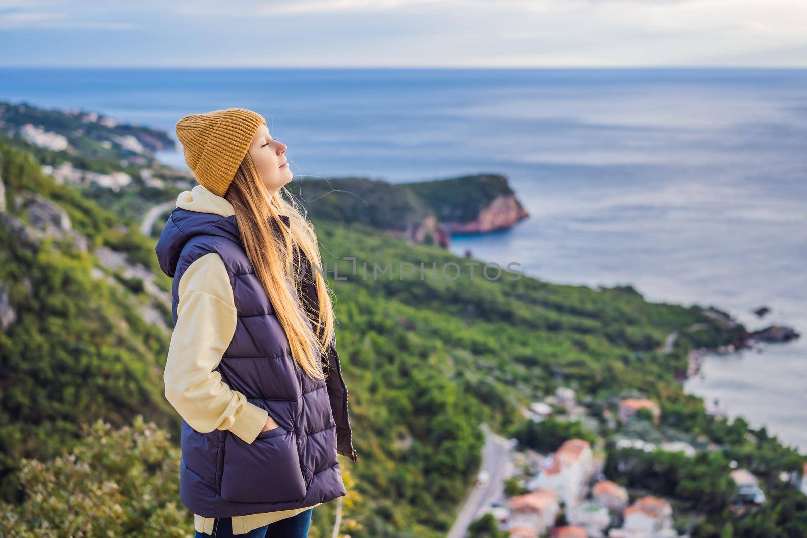 Woman in the mountains of Montenegro in warm clothes. Travel to Montenegro in spring, autumn, winter.