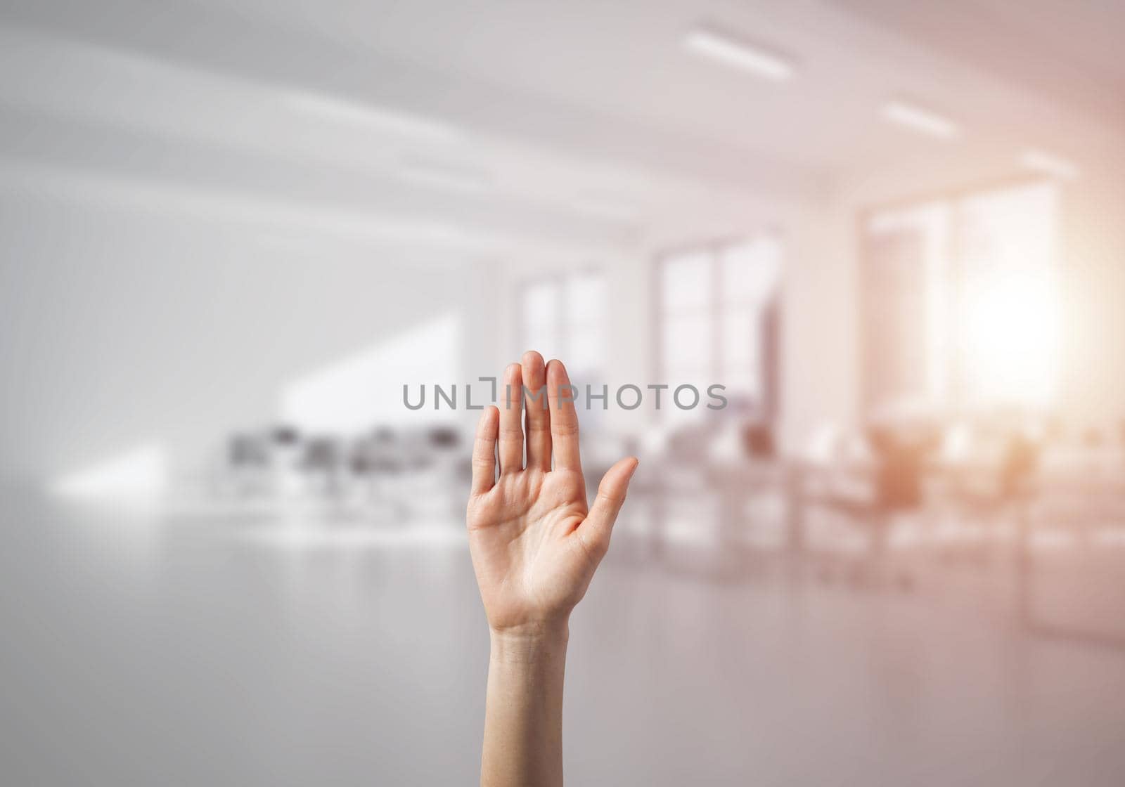 Close of woman hand touching screen with palm and office at background