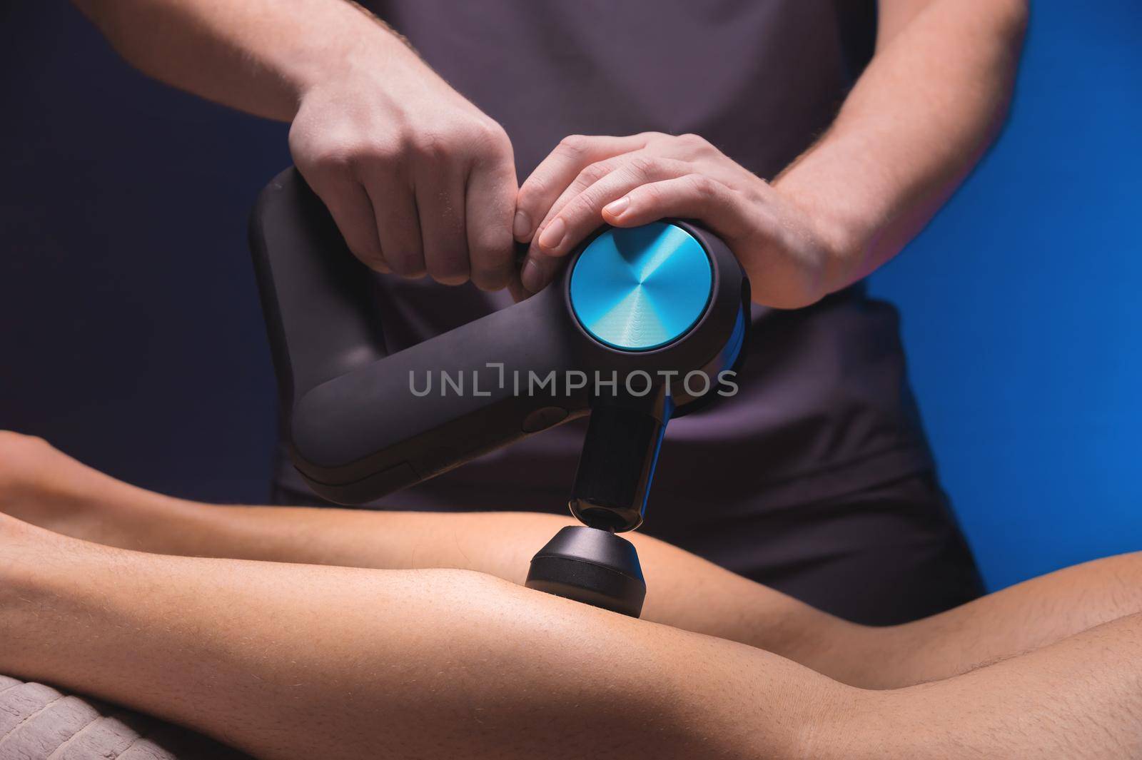 Percussion massage on the back of the leg. Massage the back of the thigh and the back of the calf muscles. Working as a percussion massager.