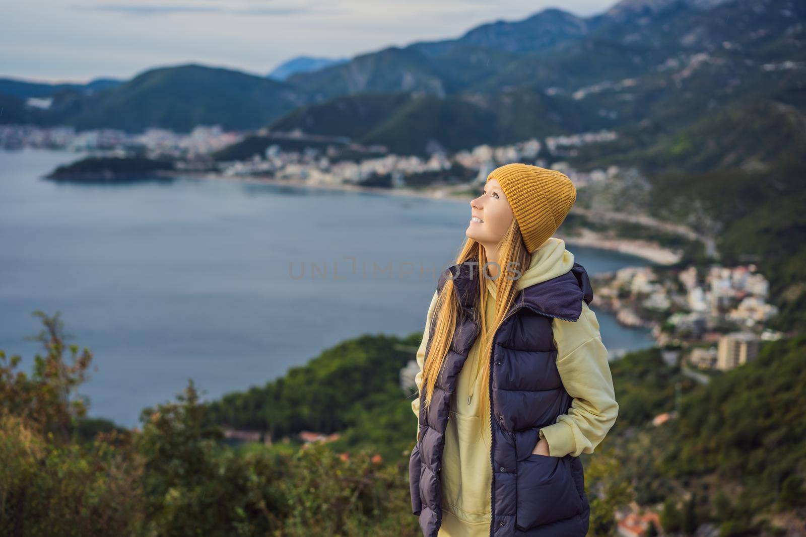 Woman in the mountains of Montenegro in warm clothes. Travel to Montenegro in spring, autumn, winter by galitskaya