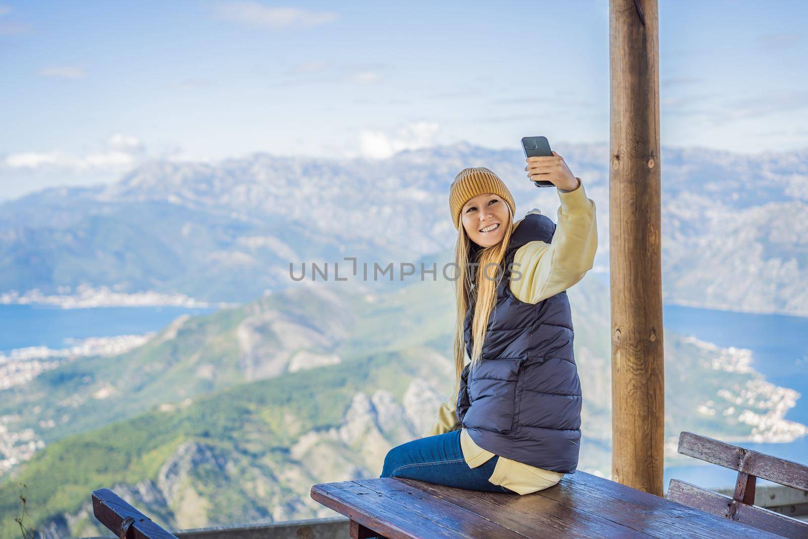 Woman tourist enjoys the view of Kotor. Montenegro. Bay of Kotor, Gulf of Kotor, Boka Kotorska and walled old city. Travel to Montenegro conceptFortifications of Kotor is on UNESCO World Heritage List since 1979.