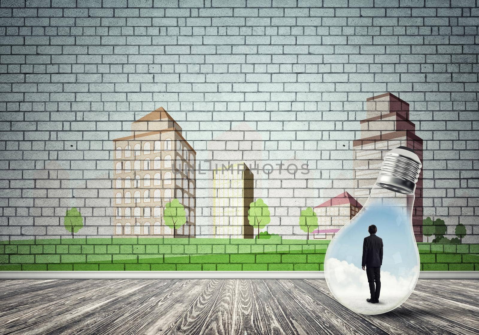 Businessman inside light bulb against city drawn concept