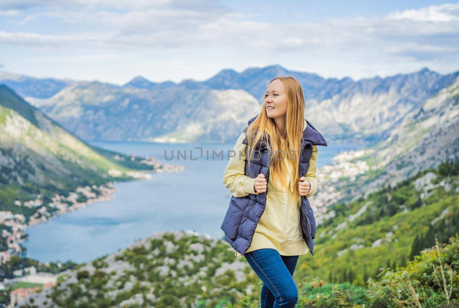 Woman tourist enjoys the view of Kotor. Montenegro. Bay of Kotor, Gulf of Kotor, Boka Kotorska and walled old city. Travel to Montenegro concept. Fortifications of Kotor is on UNESCO World Heritage List since 1979 by galitskaya