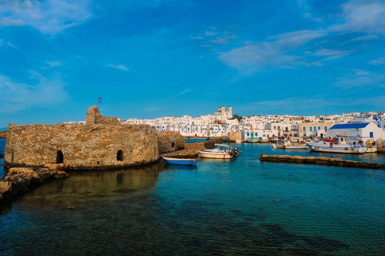 Picturesque view of Naousa town in famous tourist attraction Paros island, Greece with traditional whitewashed houses and small venetian castle fort