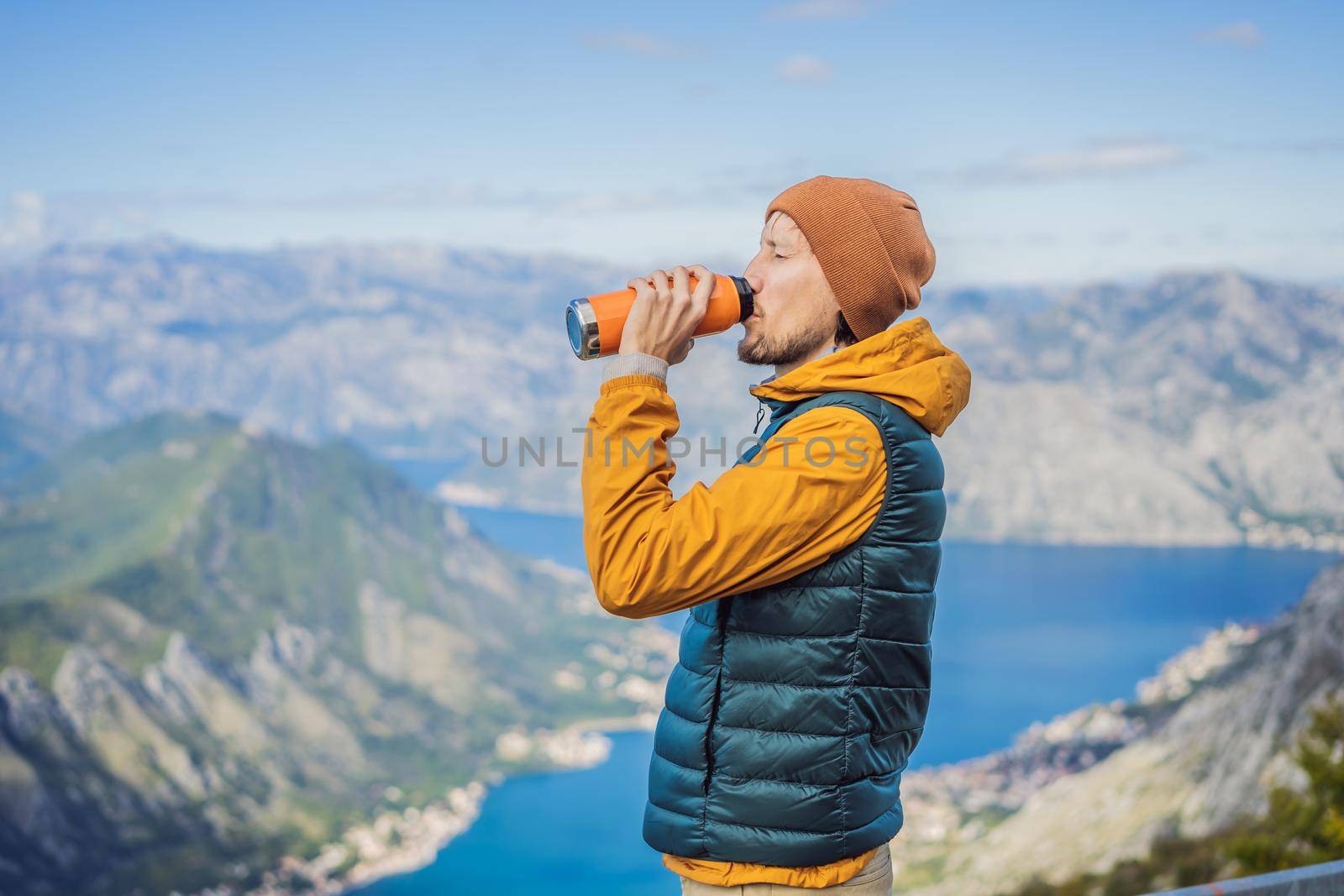 Man tourist enjoys the view of Kotor. Montenegro. Bay of Kotor, Gulf of Kotor, Boka Kotorska and walled old city. Travel to Montenegro concept. Fortifications of Kotor is on UNESCO World Heritage List since 1979 by galitskaya