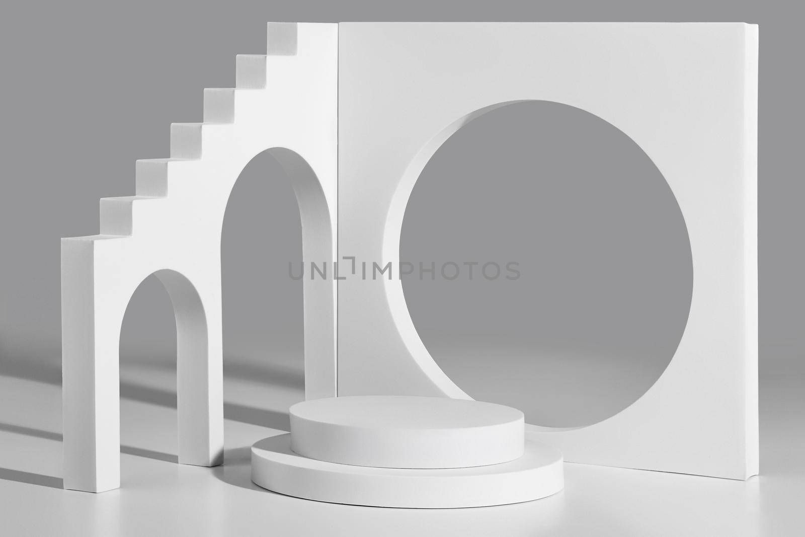 Empty cylindrical podium surrounded by simple geometrical figures with steps, arched and round openings on light gray background. Abstract showcase mockup for product presentation
