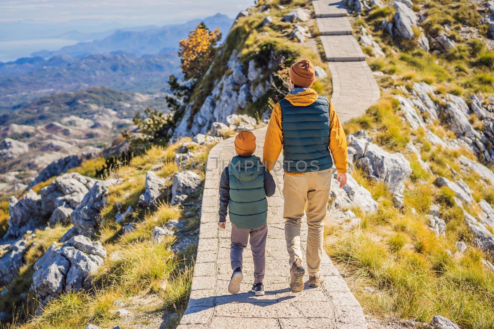 Dad and son travellers in mountain landscape at national park Lovcen, Montenegro. Travel to Montenegro with children concept by galitskaya