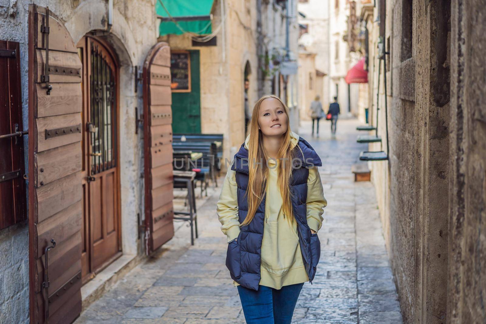 Woman tourist enjoying Colorful street in Old town of Kotor on a sunny day, Montenegro. Travel to Montenegro concept.