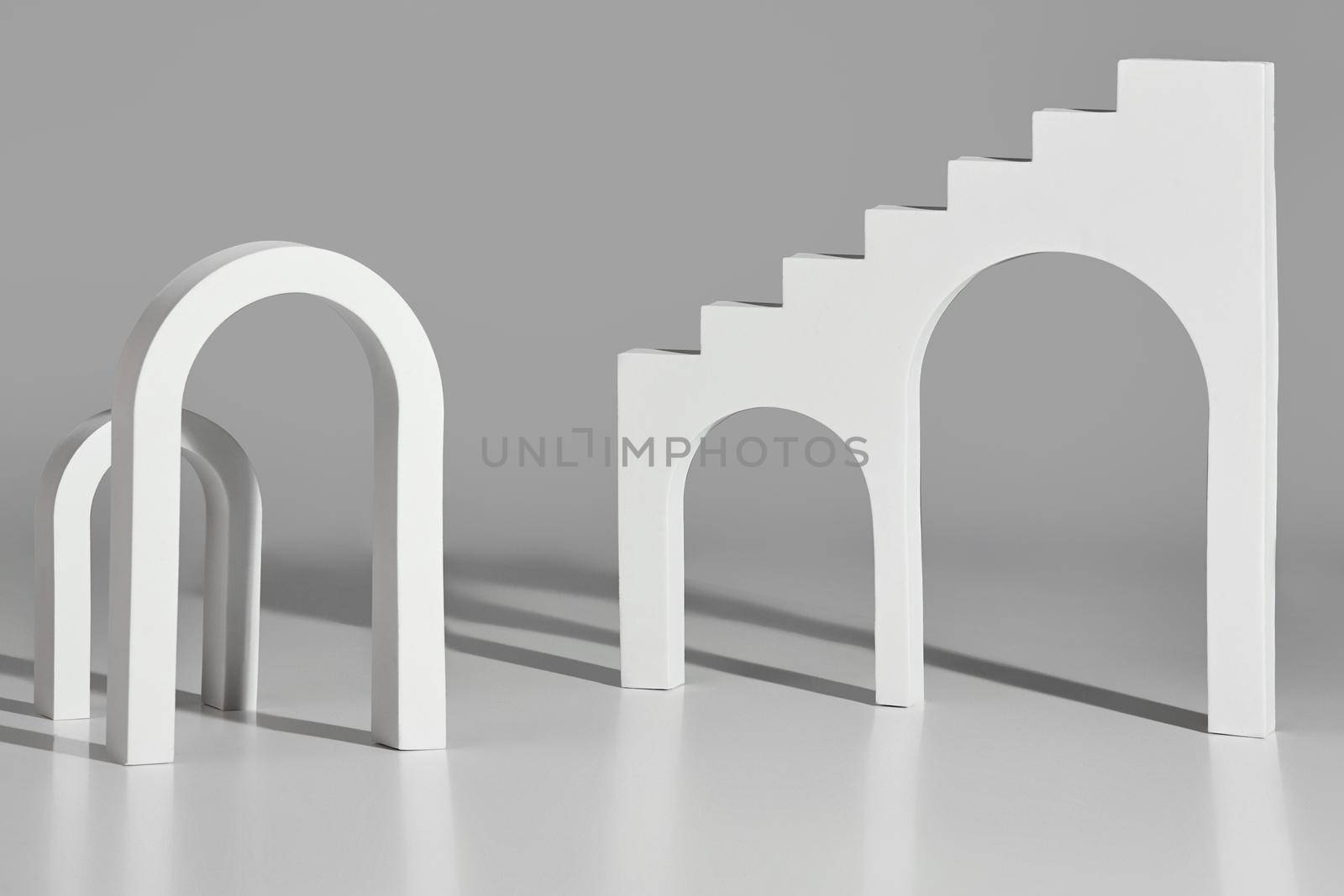Monochrome illustration with simple architectural elements. White arches of different sizes and stairs with arched openings on light gray background. 3D rendering
