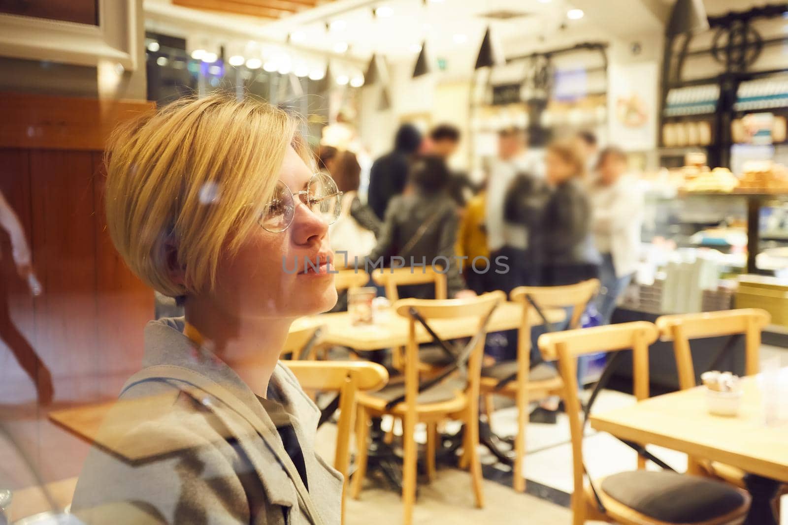 Closeup portrait of an elegant middle aged woman wearing glasses in cafe