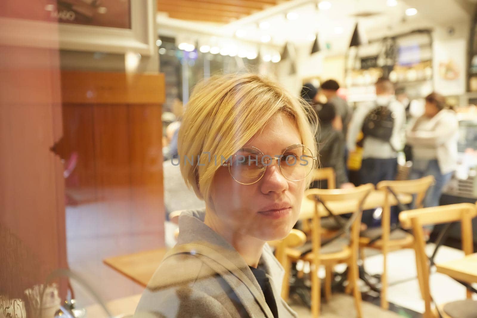 Closeup portrait of an elegant middle aged woman wearing glasses in cafe