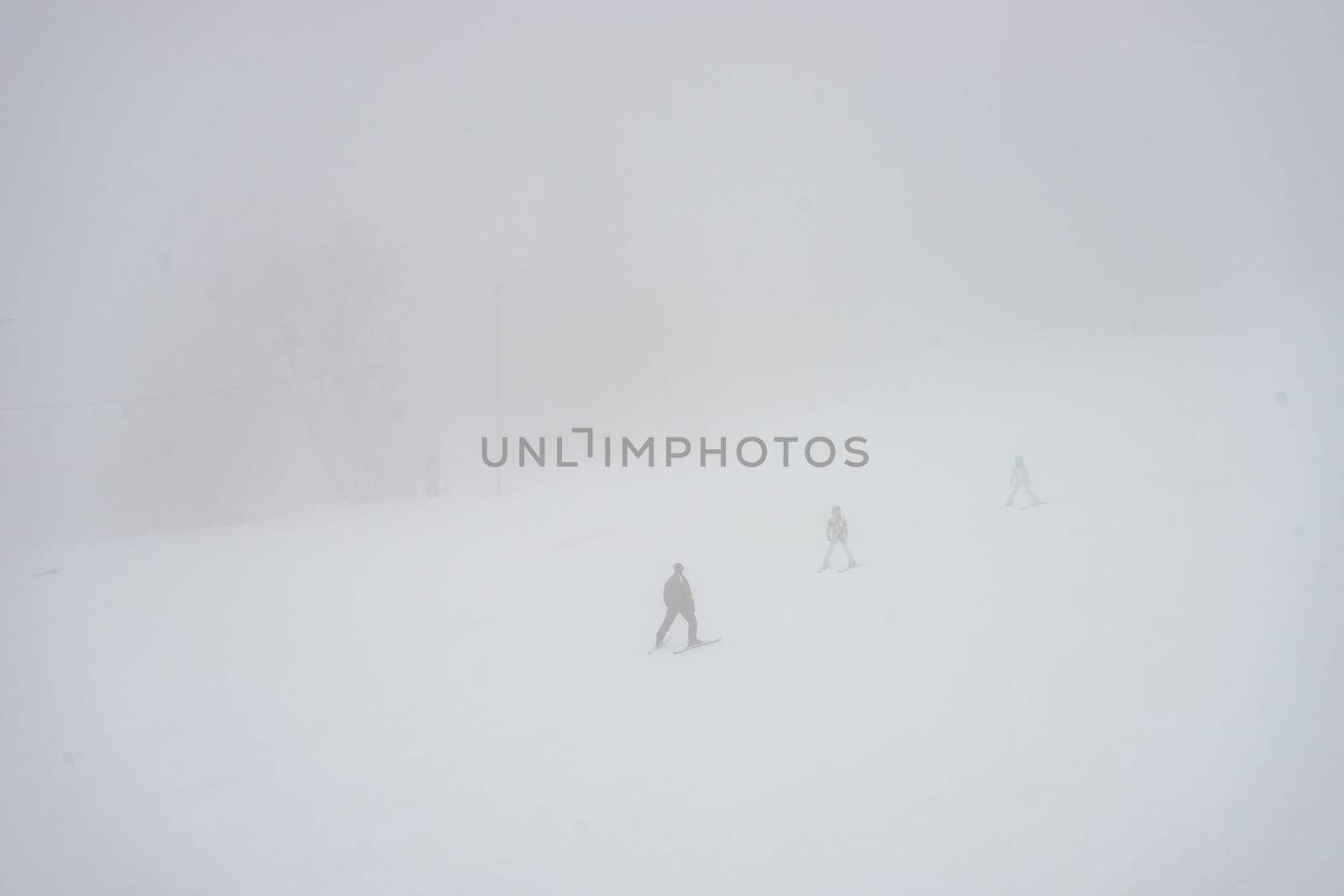 Skiers on the slopes in misty day in Bakuriani resort in Georgia