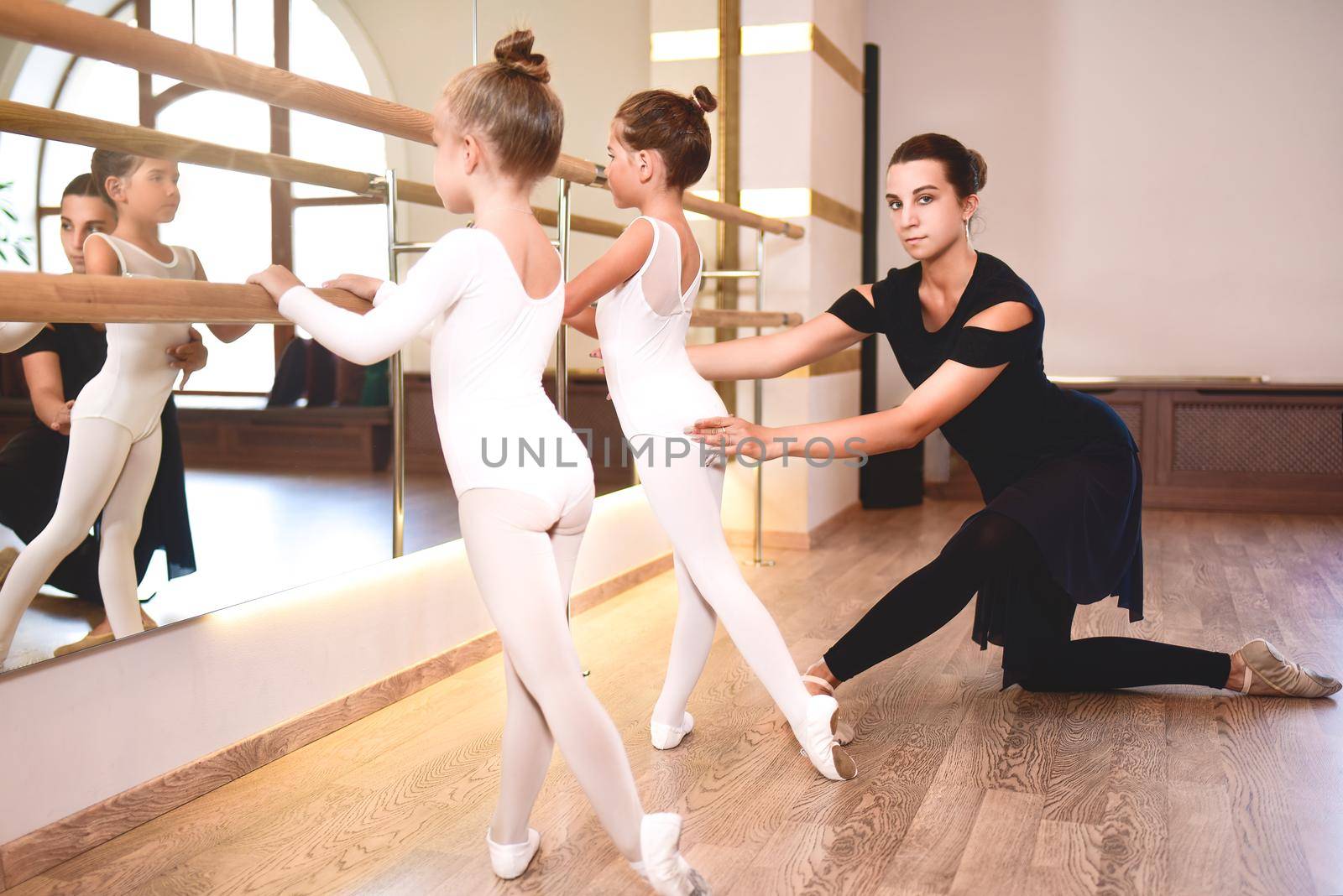 Girls are engaged in choreography in the ballet school.Young ballet teacher and by Nickstock