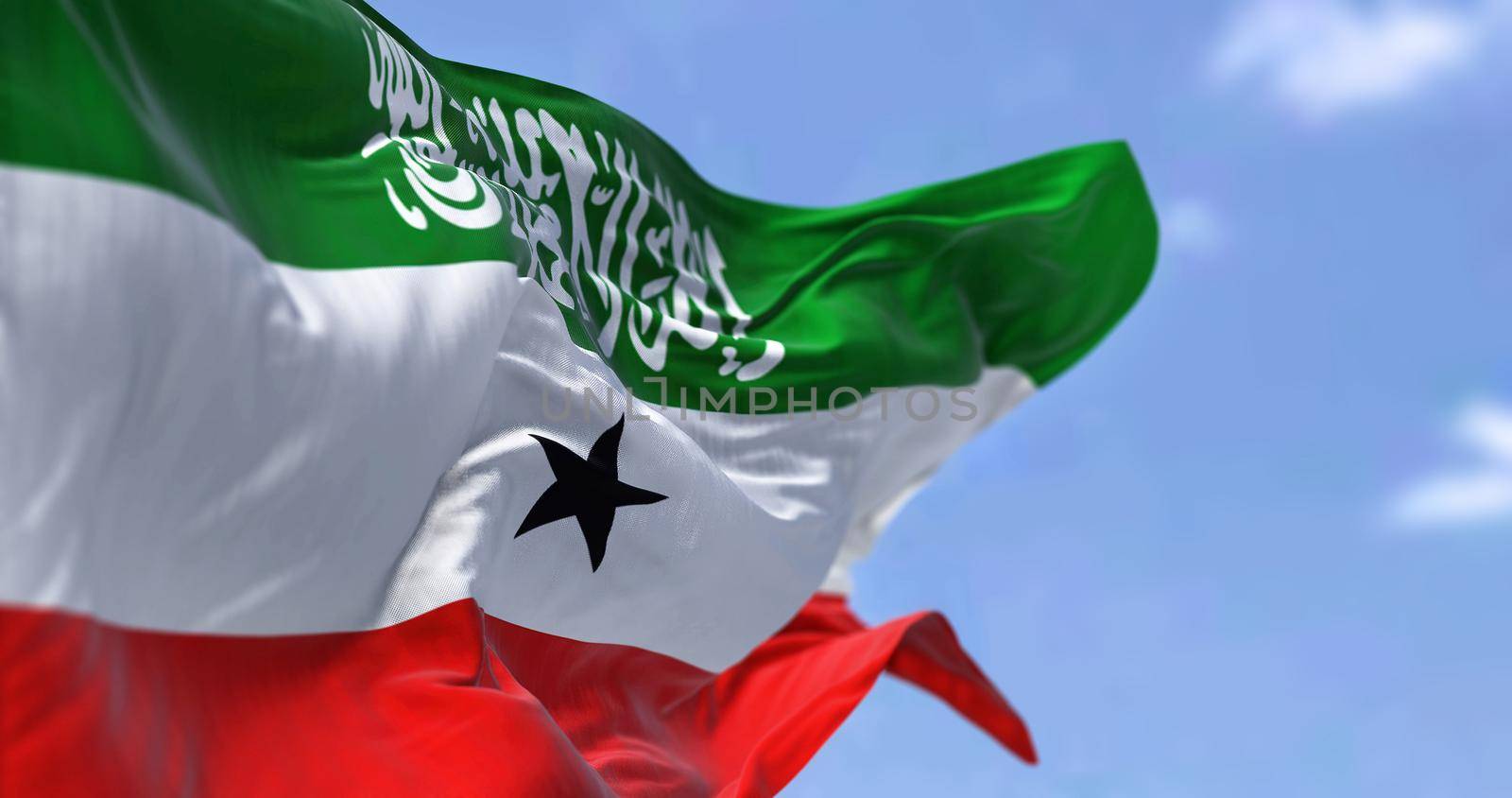 side close-up view of Somaliland national flag waving in the wind. In the background there is a clear sky. Patriotism and pride. Unrecognized state located in the Horn of Africa. Selective focus