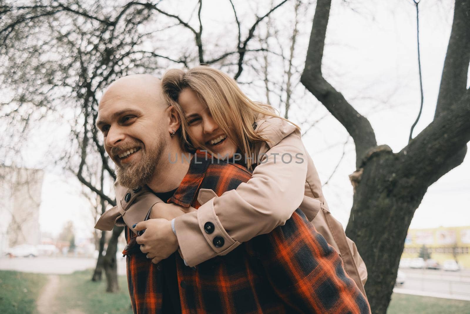 Loving couple embrace with each other. Tree on background. Hipster