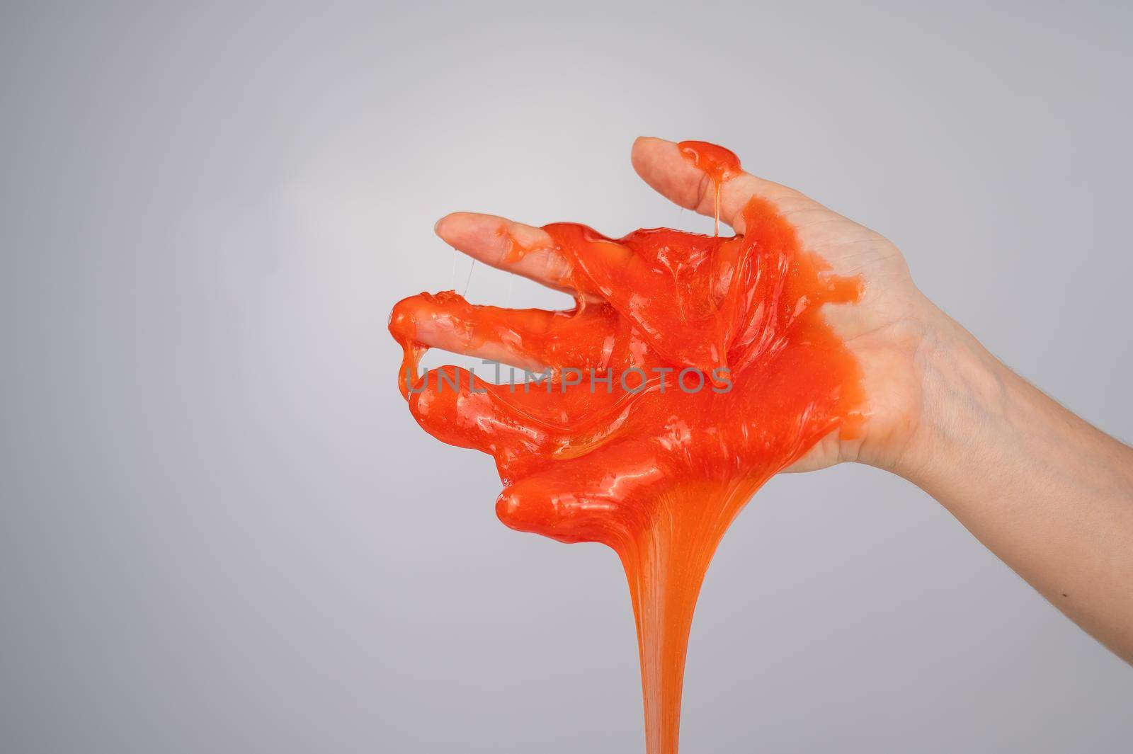 Red slime flowing down from a woman's hand on a white background