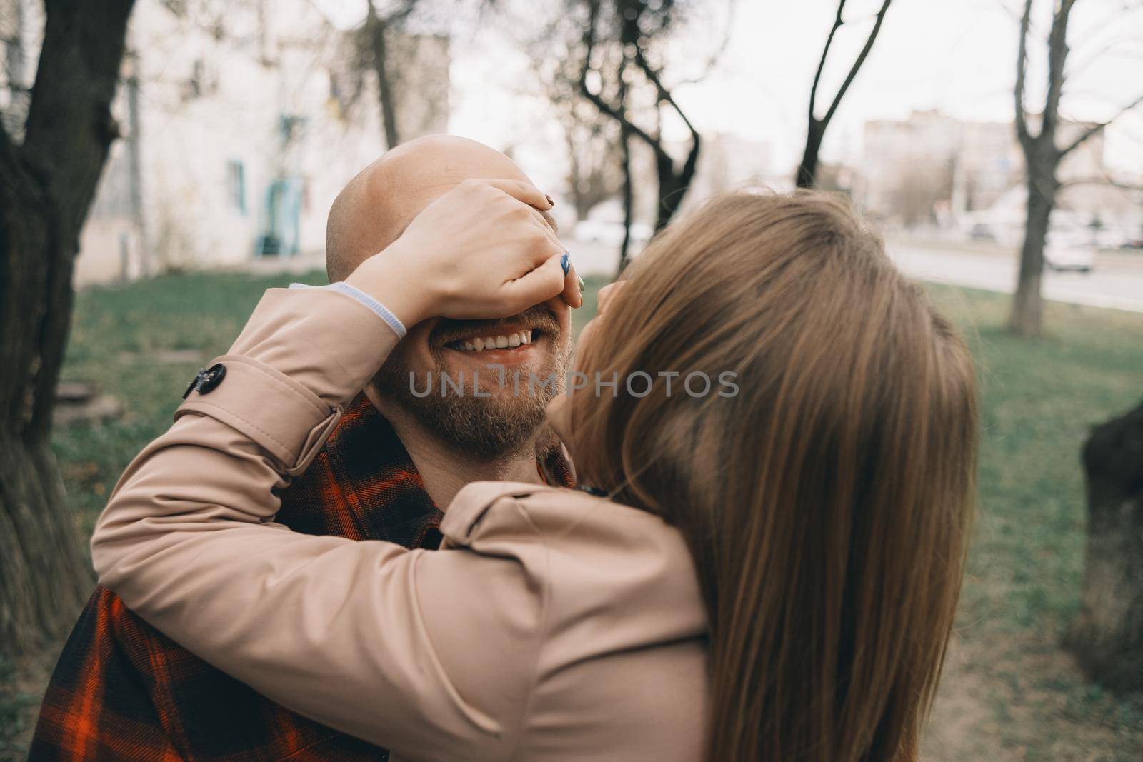Loving couple embrace with each other. Tree on background. Hipster