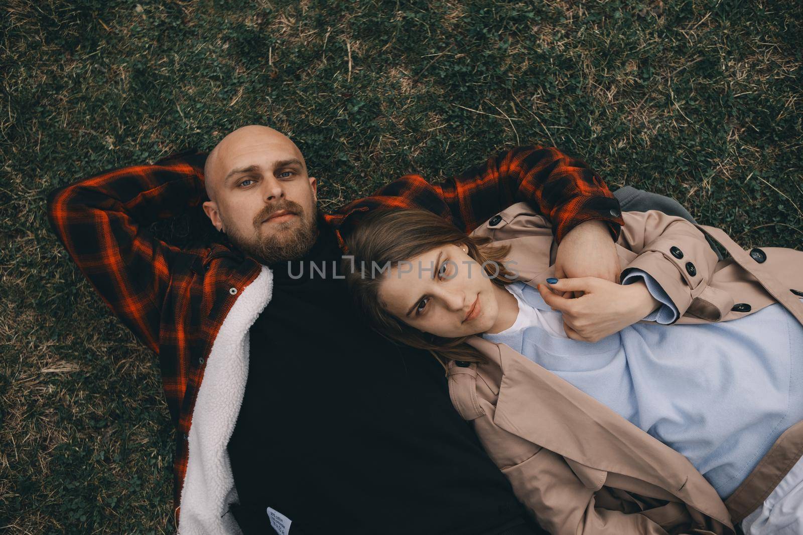 young couple laying on grass. summer love outdoors