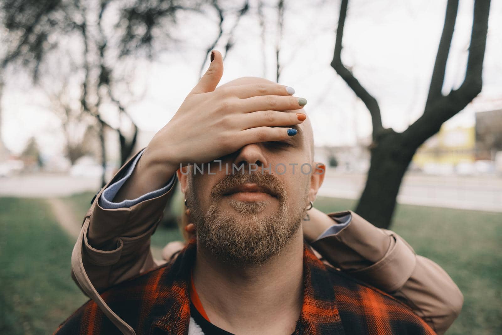 girl closes her lover's eyes from behind. hipster