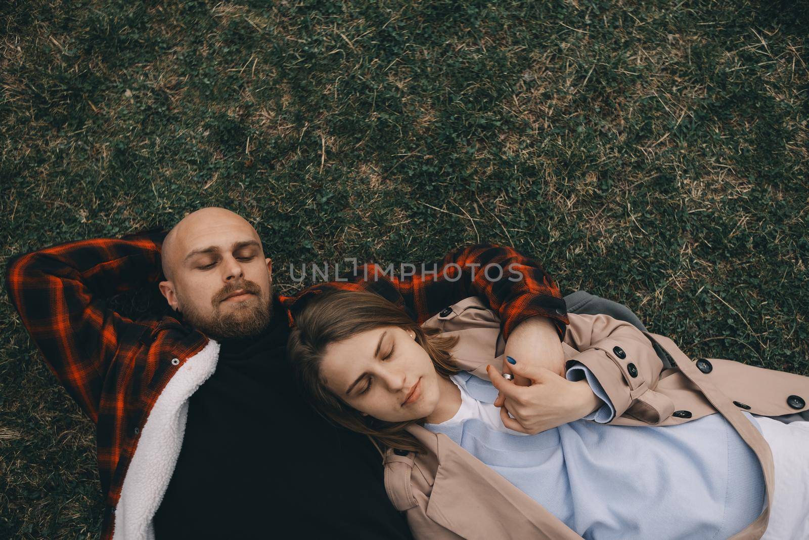 young couple laying on grass. summer love outdoors