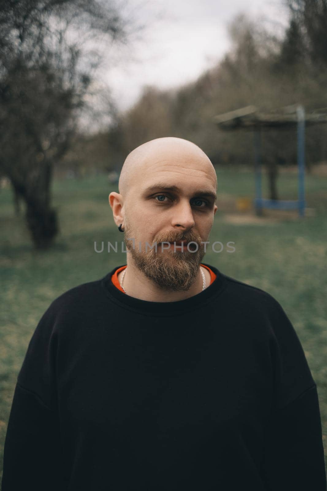 A white man with bald head and beard has a rest in a park by Symonenko