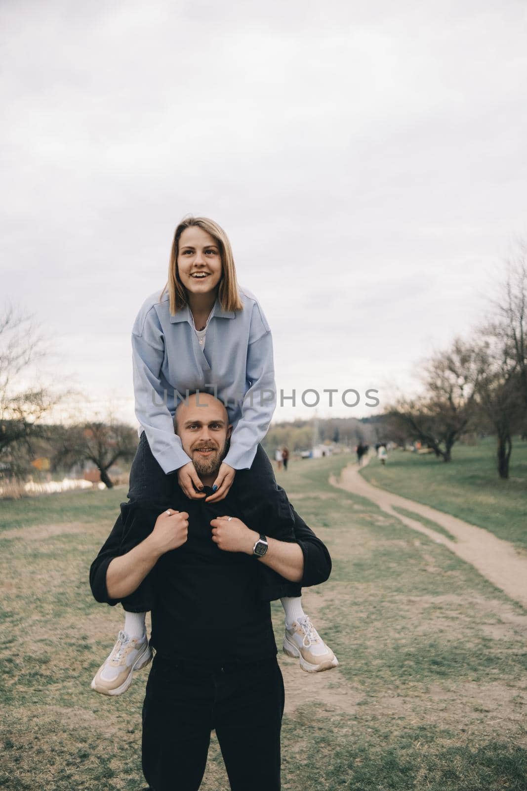 man carries a woman in his arms in the park and they have fun and happy