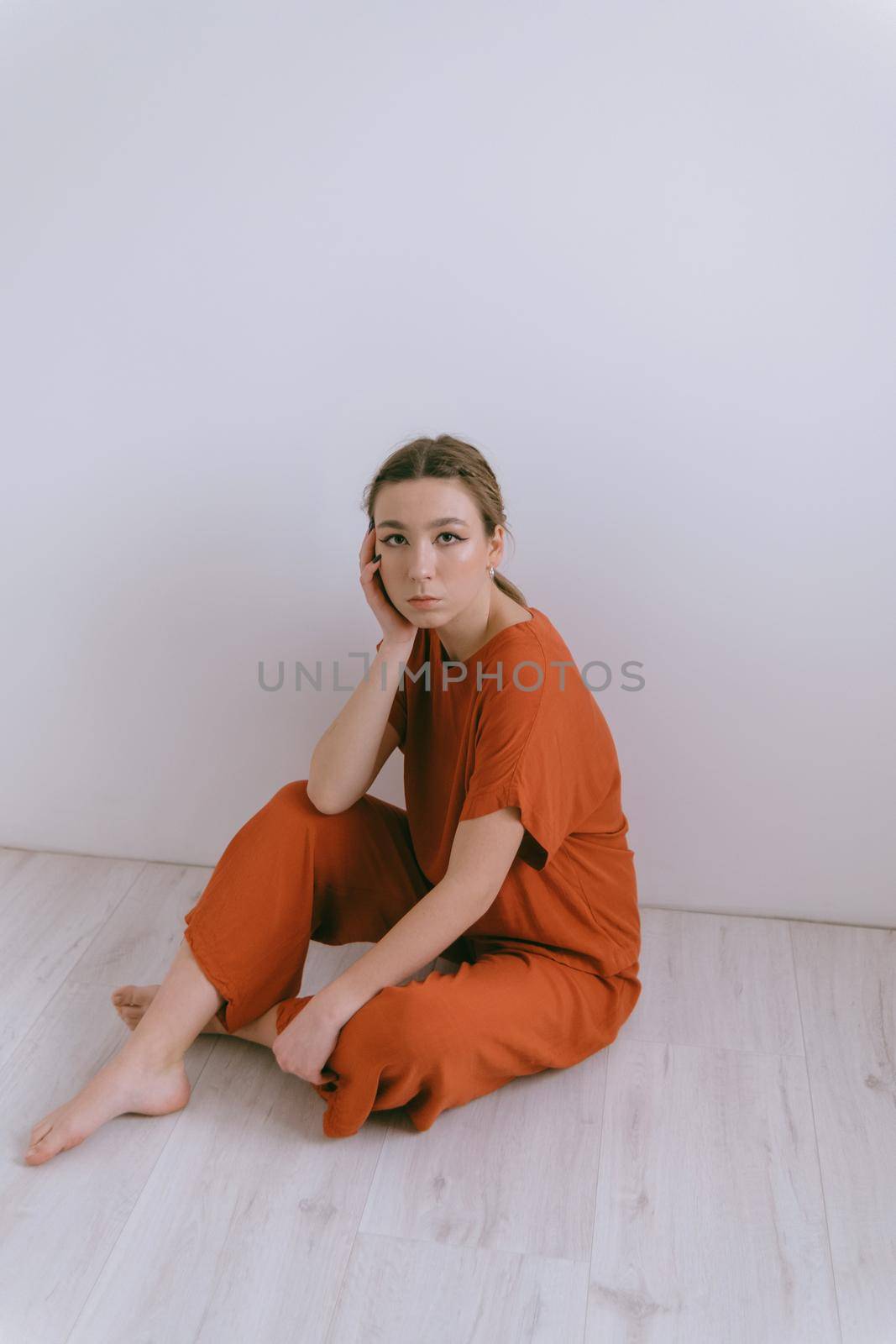 Portrait of young caucasian woman in red cloth. Dreamy