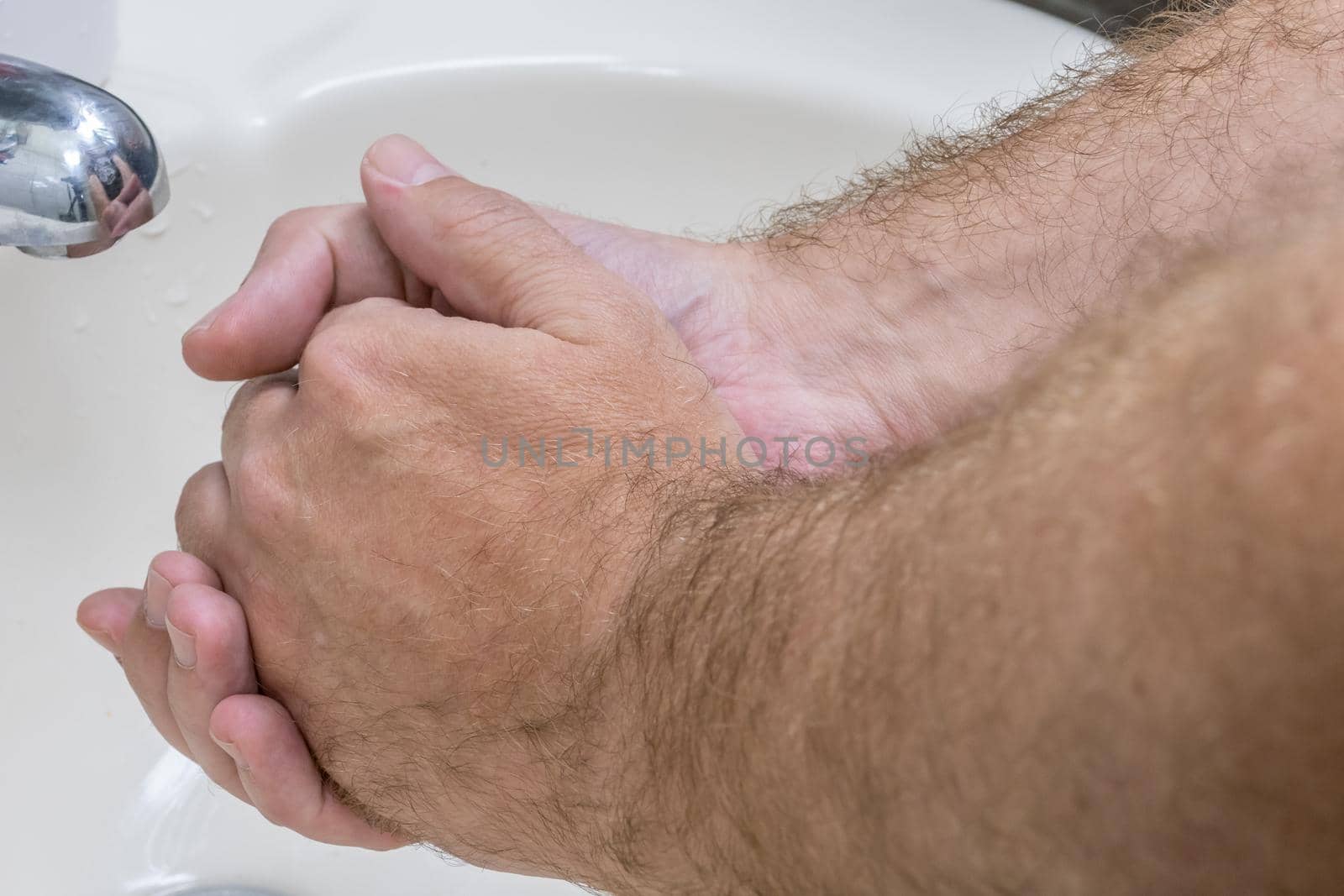 Man washing hands in basin close-up by imagesbykenny