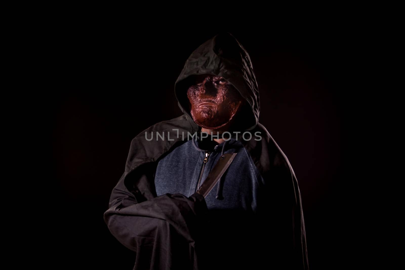 Scary killer in mask holding knife by imagesbykenny