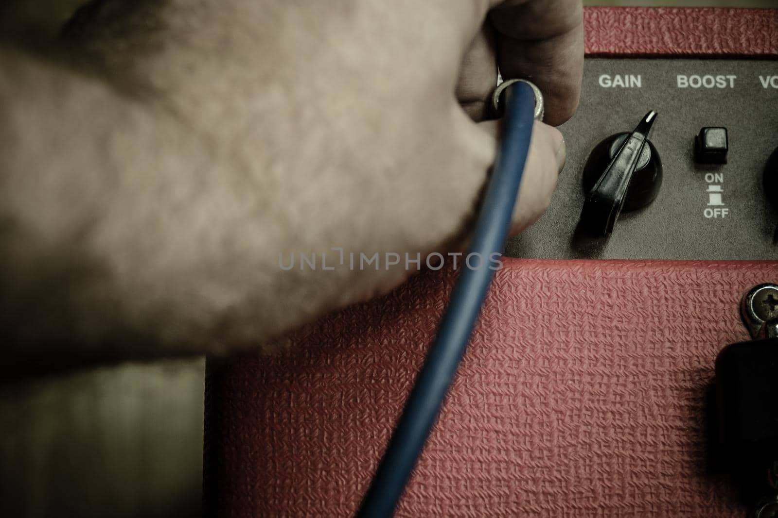 Close up of hand plugging in jack on amp by imagesbykenny