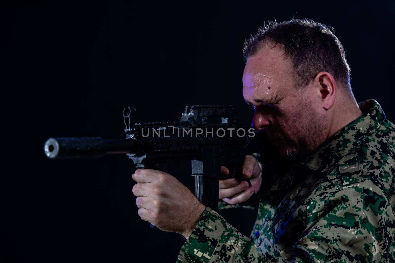 Soldier in army fatigues holding assault rifle