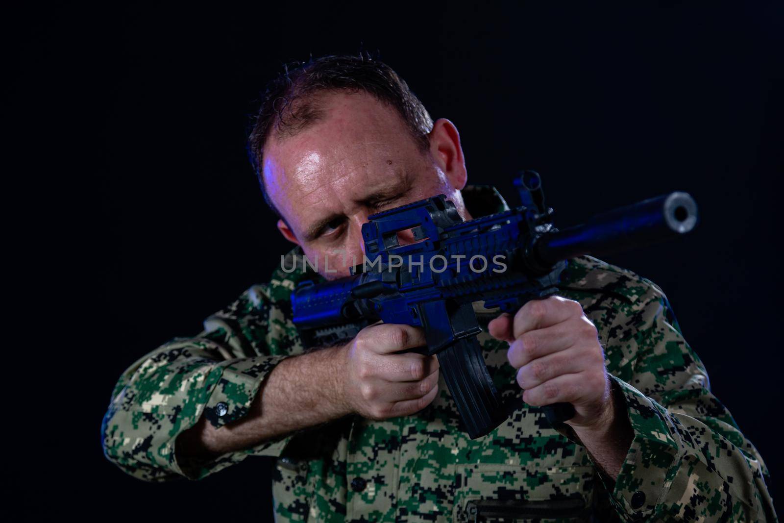 Soldier in army fatigues holding assault rifle
