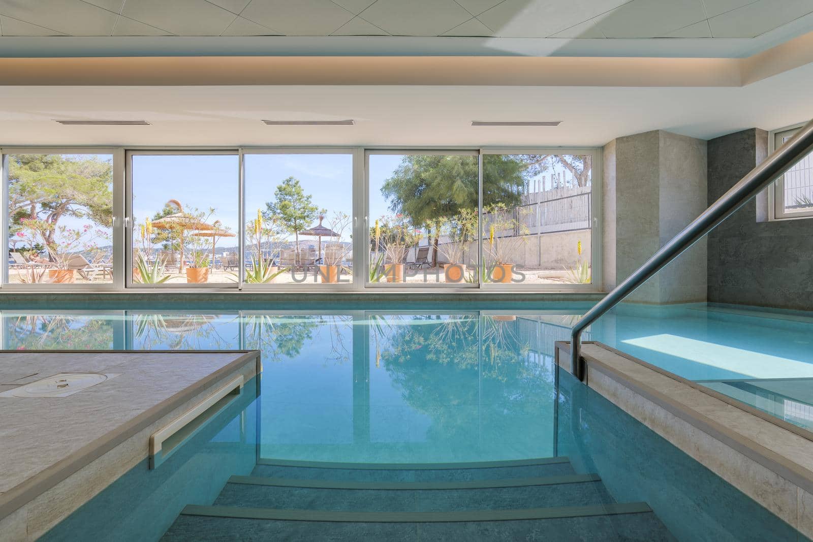 Steps and railing entrance in a swimming pool of a hotel with beach view.