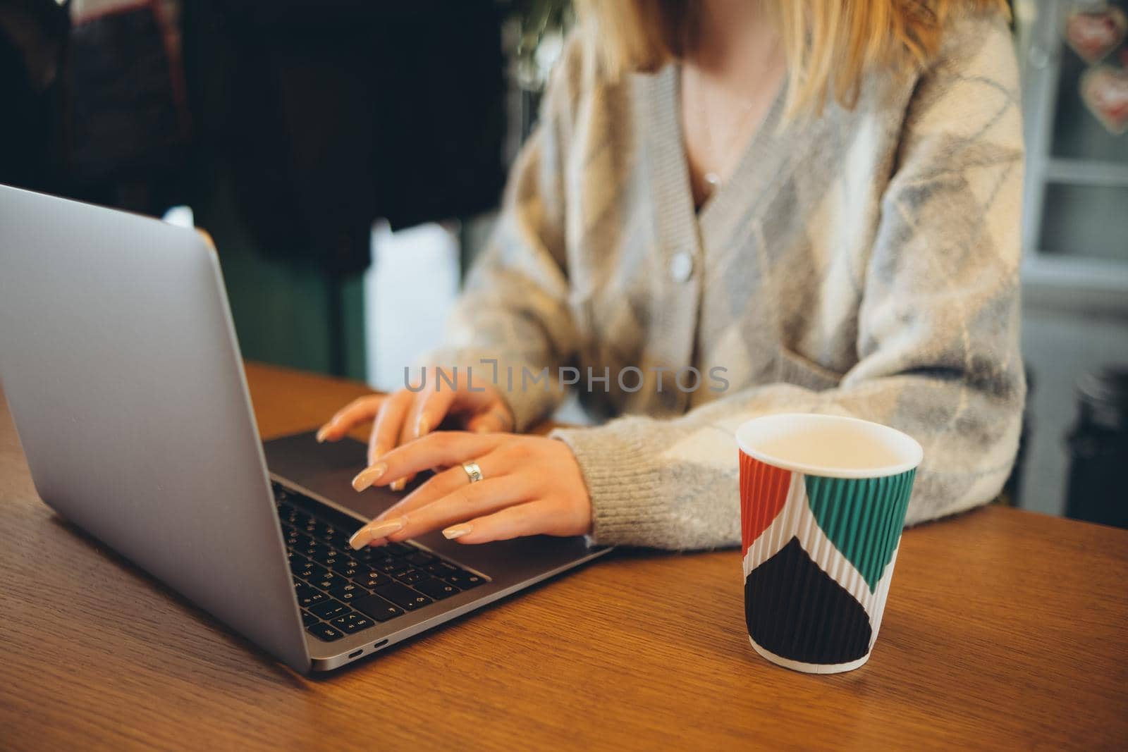 Girl working at her laptop sitting in the cafe happy