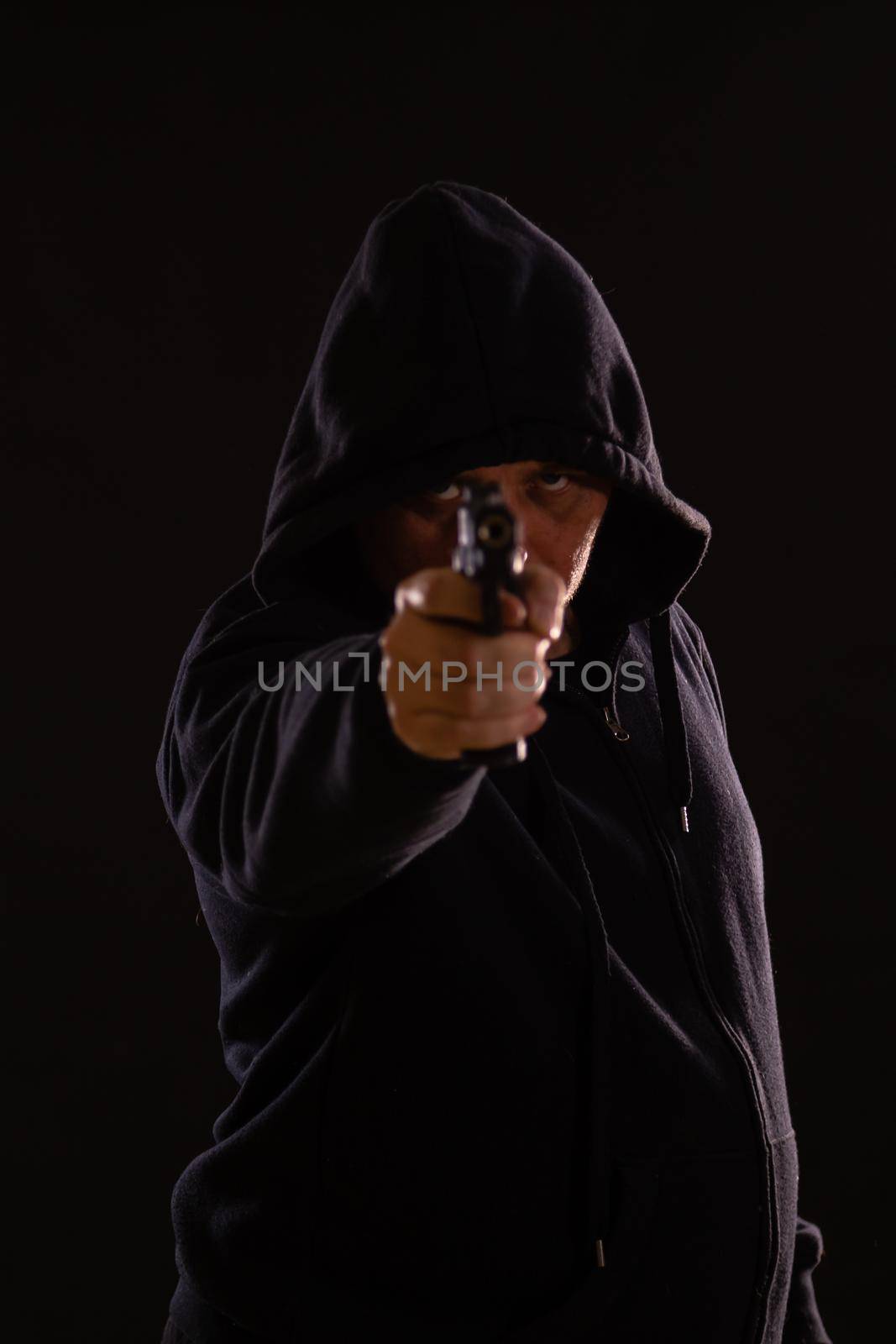 Man in black hoodie points pistol by imagesbykenny