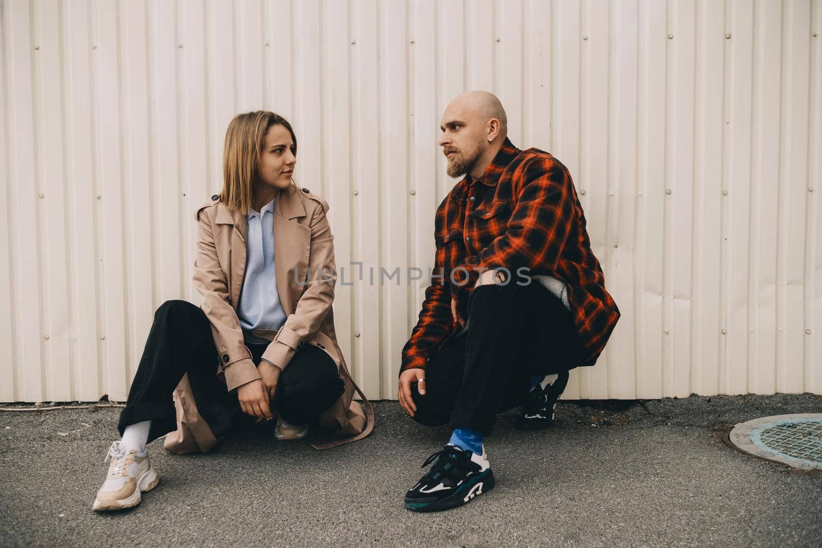 Loving couple stand near wall and look in camera by Symonenko